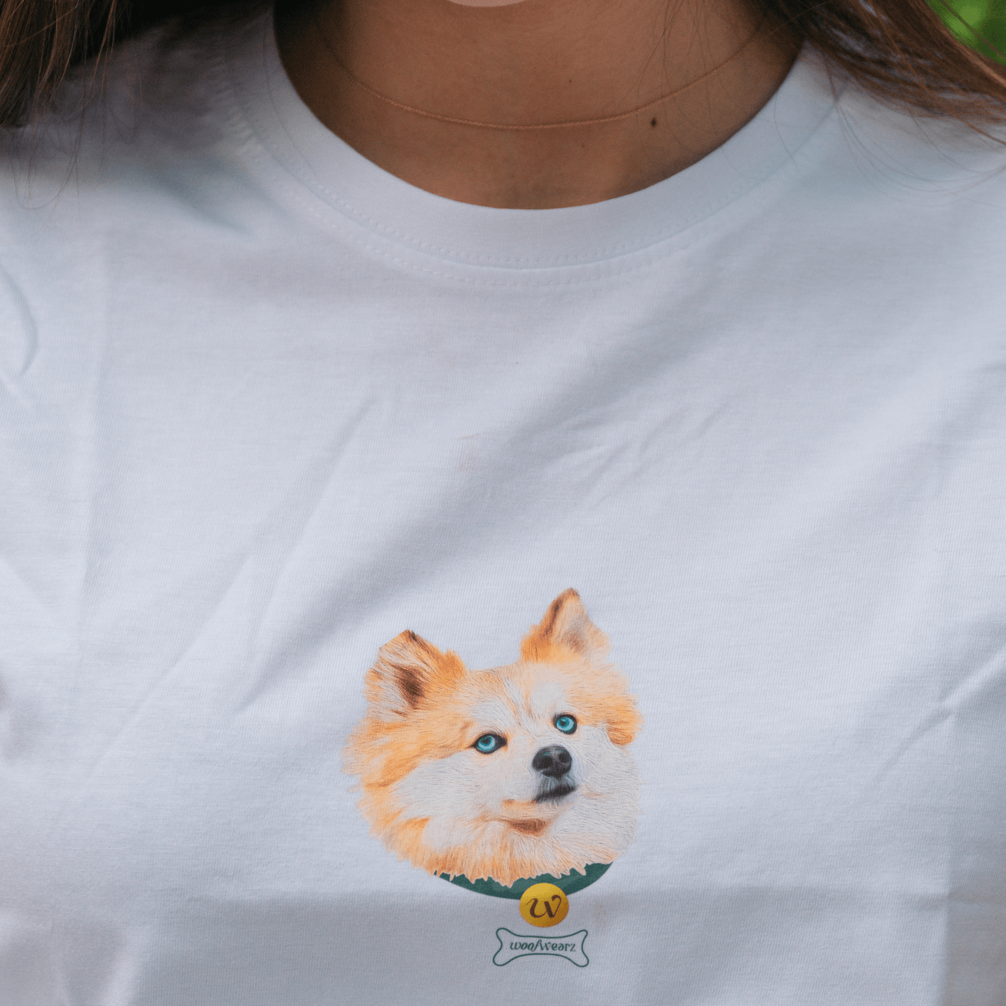 Vista frontal de camiseta con medalla bordada y nombre de mascota
