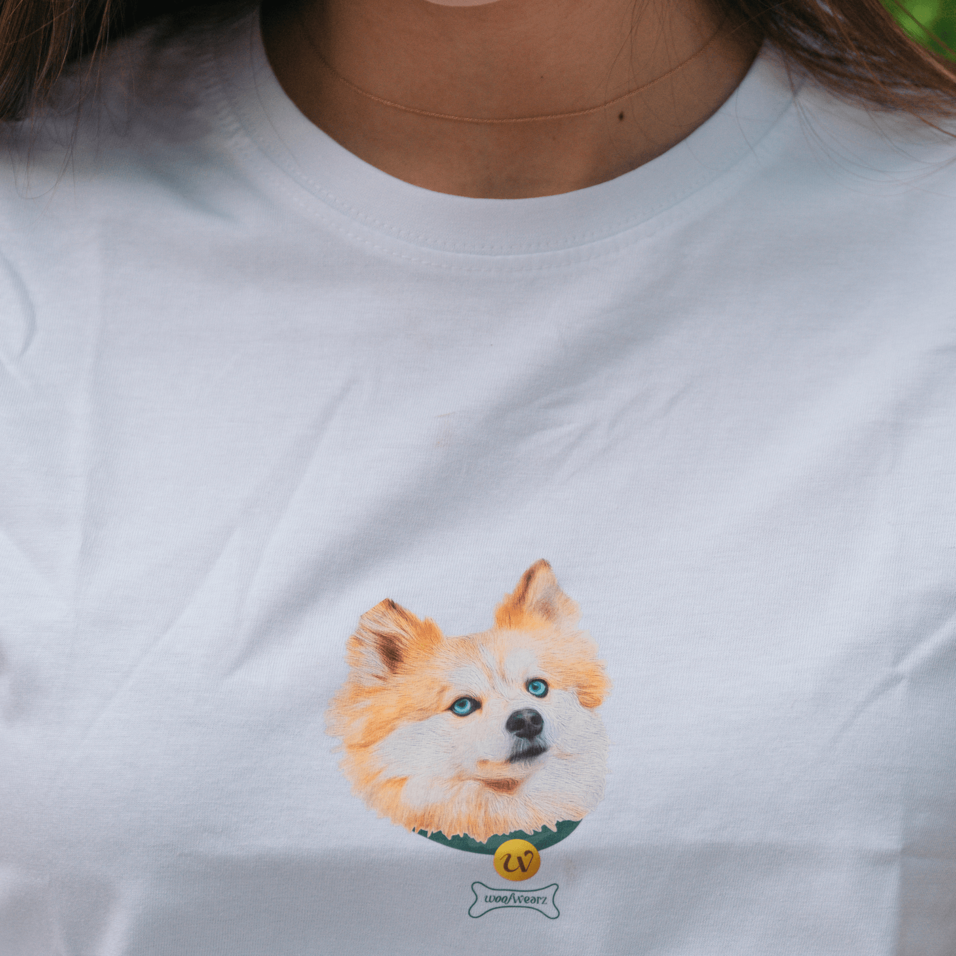 Vista frontal de camiseta con medalla bordada y nombre de mascota